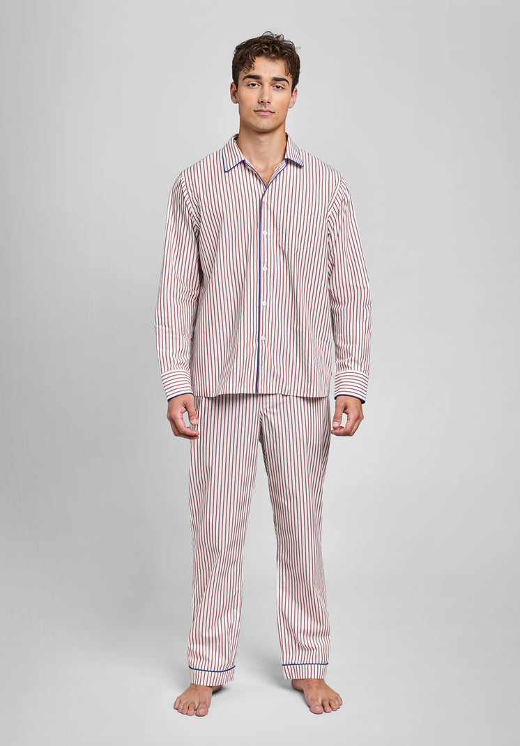 Man wearing a burgundy and white long-sleeve striped pajama set on a gray background