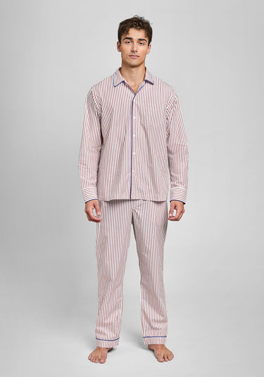 Man wearing a burgundy and white long-sleeve striped pajama set on a gray background
