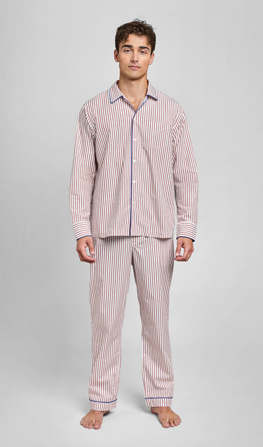 Man wearing a burgundy and white long-sleeve striped pajama set on a gray background