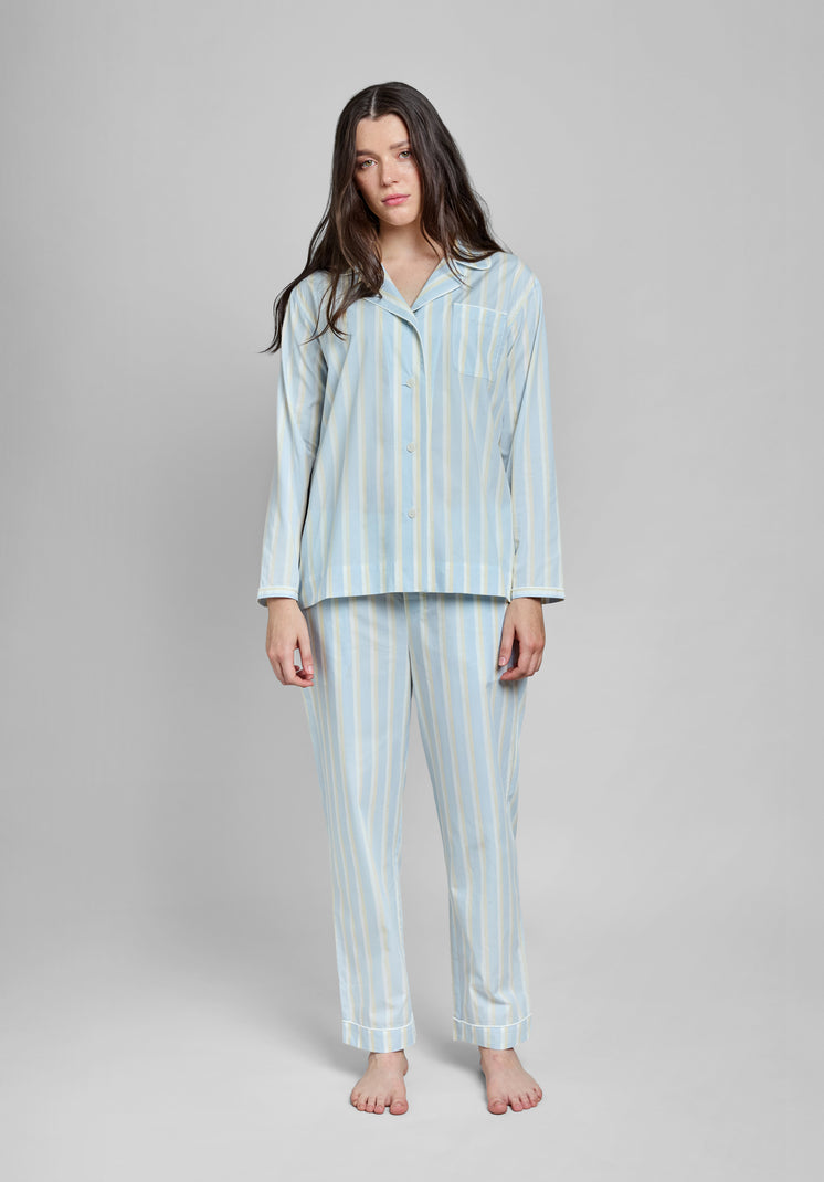 Woman wearing a light blue striped pajama set on a gray background