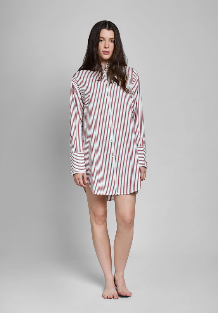 Woman wearing a burgundy and white striped long sleeve shirt dress on a gray background