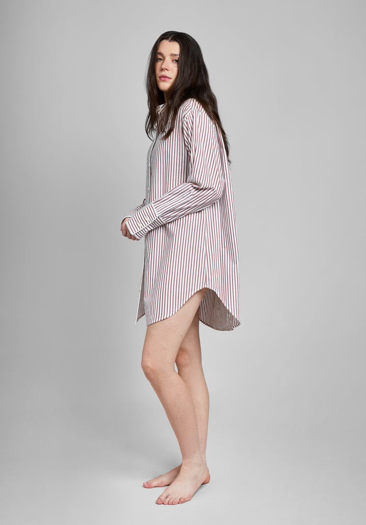 Woman wearing a burgundy and white striped long sleeve shirt dress on a gray background