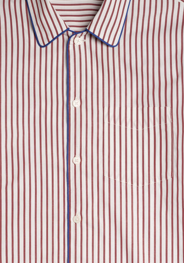 Close-up of a burgundy and white striped pajama shirt with blue trim.