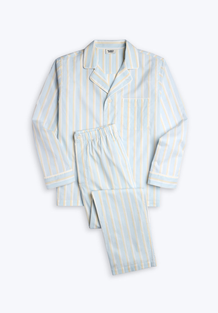 Light blue pajama set with cream and tan stripes and white piping on a white background.
