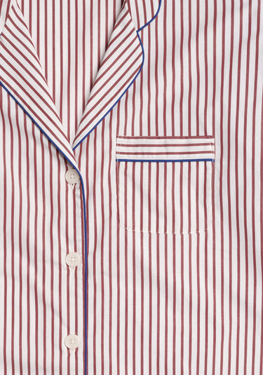 Close-up of the collar and chest pocket of a burgundy and white striped pajama shirt with blue piping.