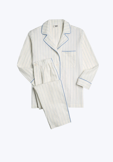 A white long-sleeve linen pajama set with blue stripes and blue piping details and a collar, consisting of a top and pants, presented against a plain background.