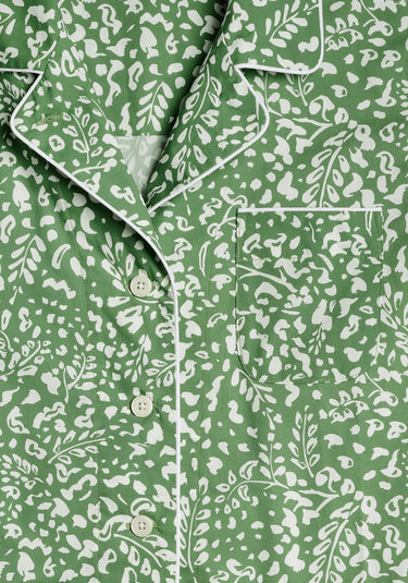 A detail of collar and chest pocket area of a green pajama shirt with a white botanical pattern.