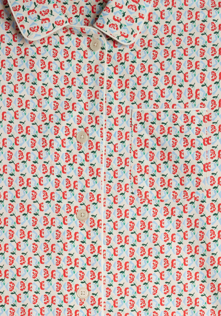 image of the placket area of a red, blue, and green floral patterned pajama shirt 